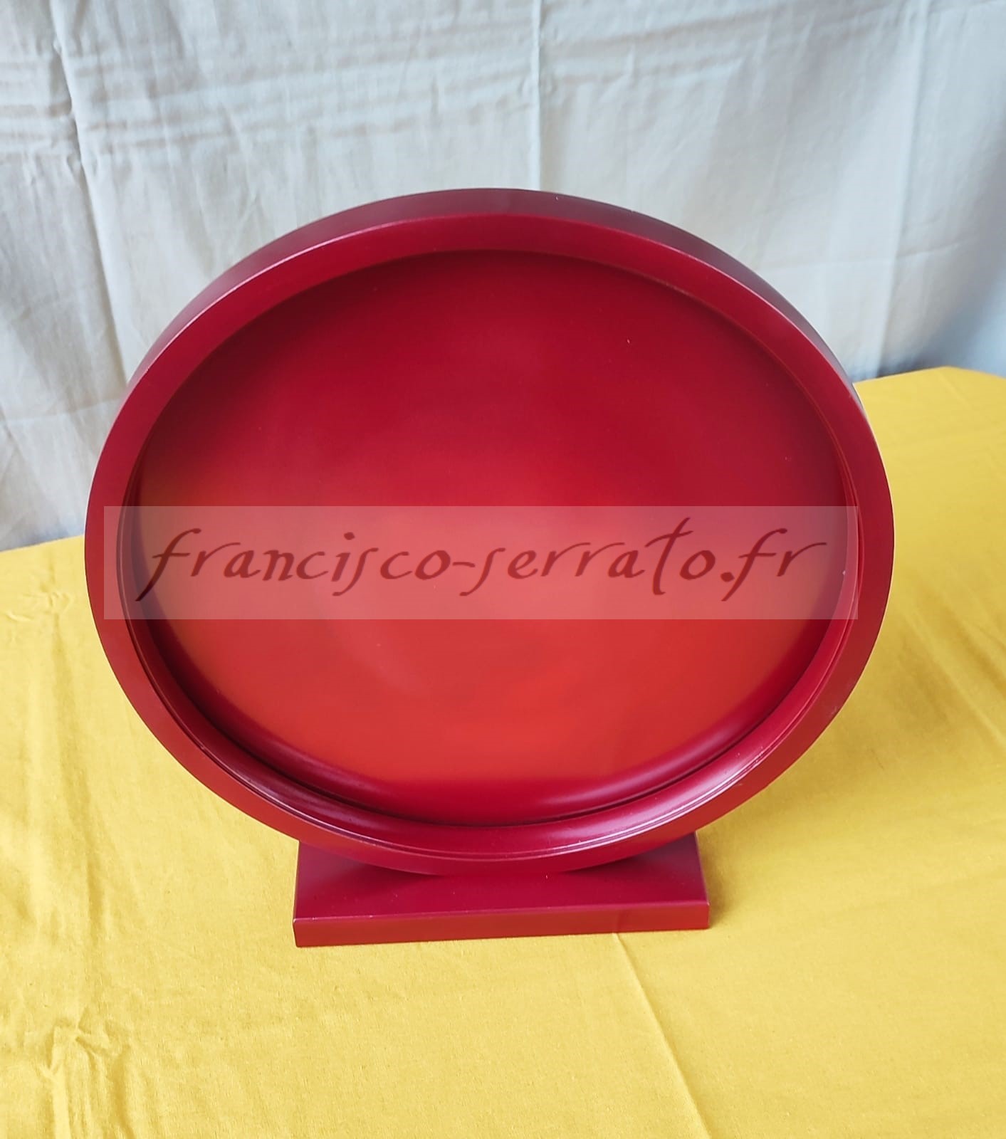 Un ruban led et un miroir peint compose cette lampe ronde de couleur rouge métallisé