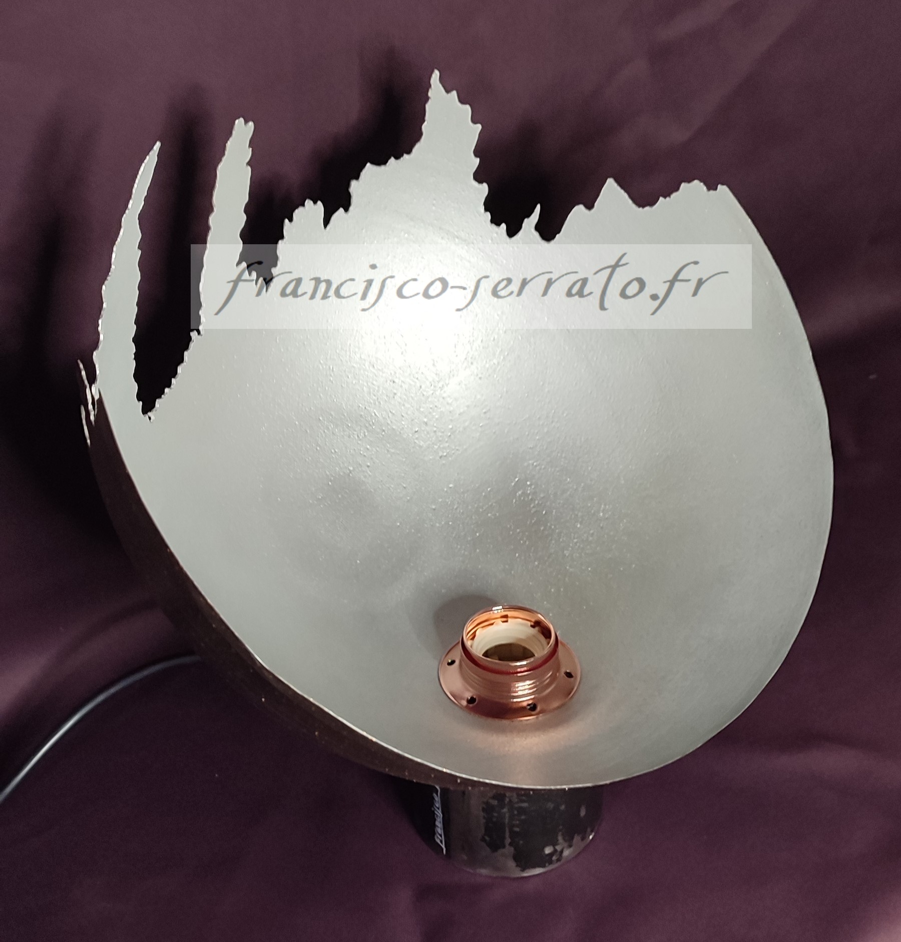 Voici une lampe atypique. Une sphère en acier découpée au plasma et soudée à un tube qui sert de pied.