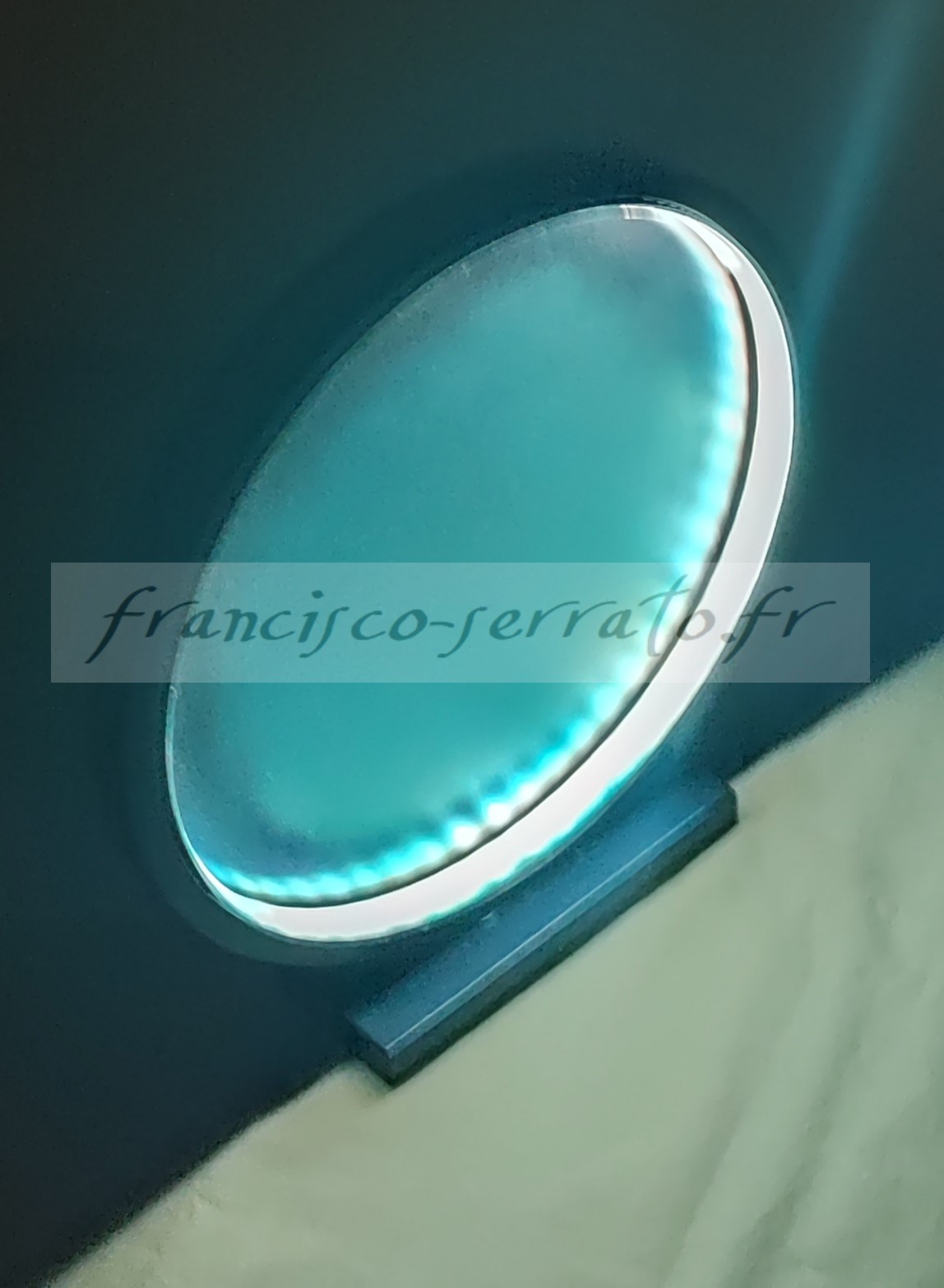 Un ruban led et un miroir peint compose cette lampe ronde de couleur bleu métallisé